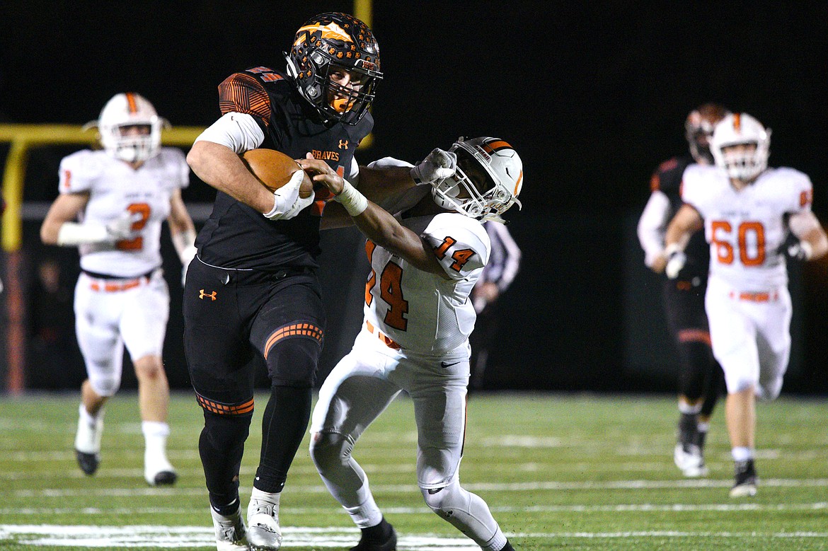 Flathead running back Blake Counts (24) stiff-arms Billings Senior defender Johnnie McClusky (14) on a 48-yard third-quarter run in a Class AA quarterfinal playoff game at Legends Stadium on Friday. (Casey Kreider/Daily Inter Lake)