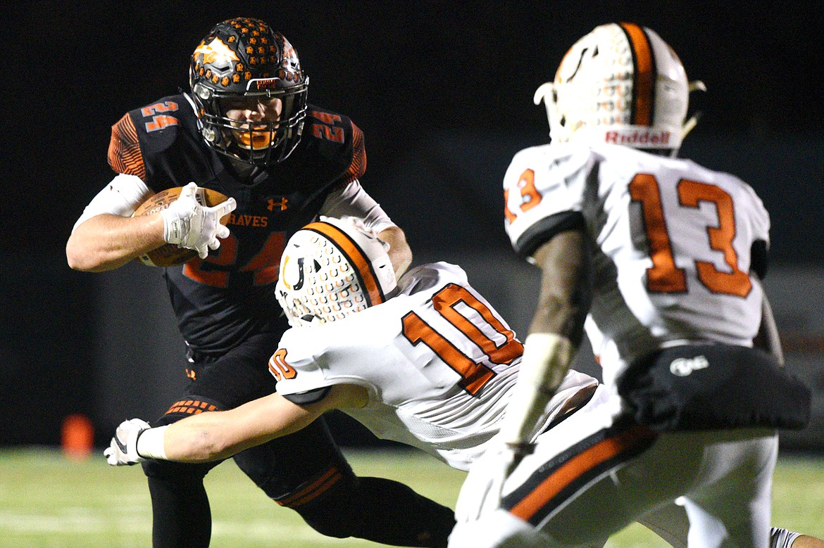 Flathead running back Blake Counts (24) stiff-arms Billings Senior defender Alyas Wright (10) on a third quarter run in a Class AA quarterfinal playoff game at Legends Stadium on Friday. (Casey Kreider/Daily Inter Lake)