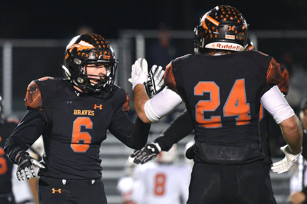 Flathead linebacker Gatlin Bruner (6) slaps the hand of running back Blake Counts (24) after the defense recovered a Billings Senior fumble in the first quarter of a Class AA quarterfinal playoff game at Legends Stadium on Friday. (Casey Kreider/Daily Inter Lake)