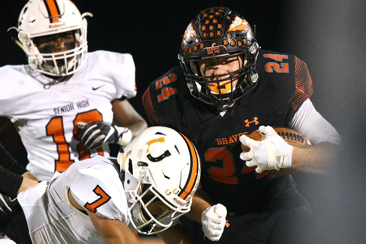 Flathead running back Blake Counts (24) lowers his shoulder into Billings Senior defensive back Junior Bergen (7) on a first quarter run in a Class AA quarterfinal playoff at Legends Stadium on Friday. (Casey Kreider/Daily Inter Lake)