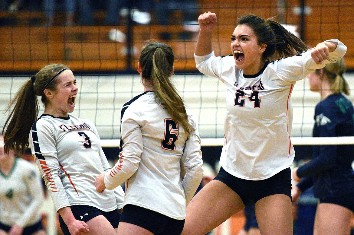 From left, Flathead's Sierra Wilhelm (3), Maddie Lindbom (6) and Taylor Henley (24) celebrate after a point against Glacier during a Western AA playoff at Flathead High School on Thursday. (Casey Kreider/Daily Inter Lake)