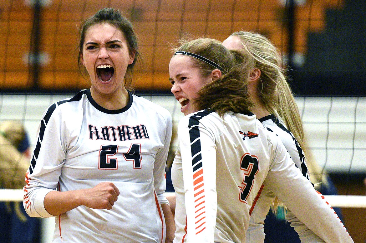 From left, Flathead's Taylor Henley (24), Sierra Wilhelm (3) and Jaylyn Fitch (4) celebrate after a point against Glacier during a Western AA playoff at Flathead High School on Thursday. (Casey Kreider/Daily Inter Lake)