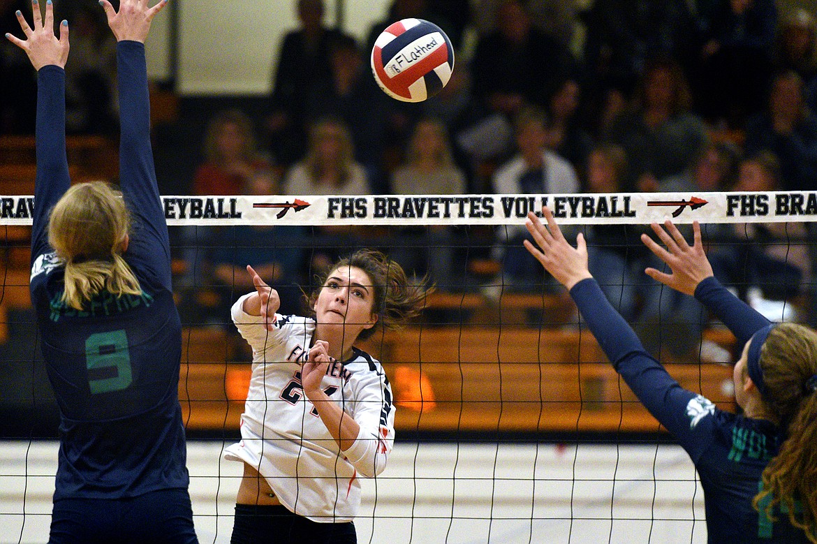 Flathead's Taylor Henley (24) goes for a kill between Glacier's Kali Gulick (9) and Emma Anderson (14) during a Western AA playoff at Flathead High School on Thursday. (Casey Kreider/Daily Inter Lake)