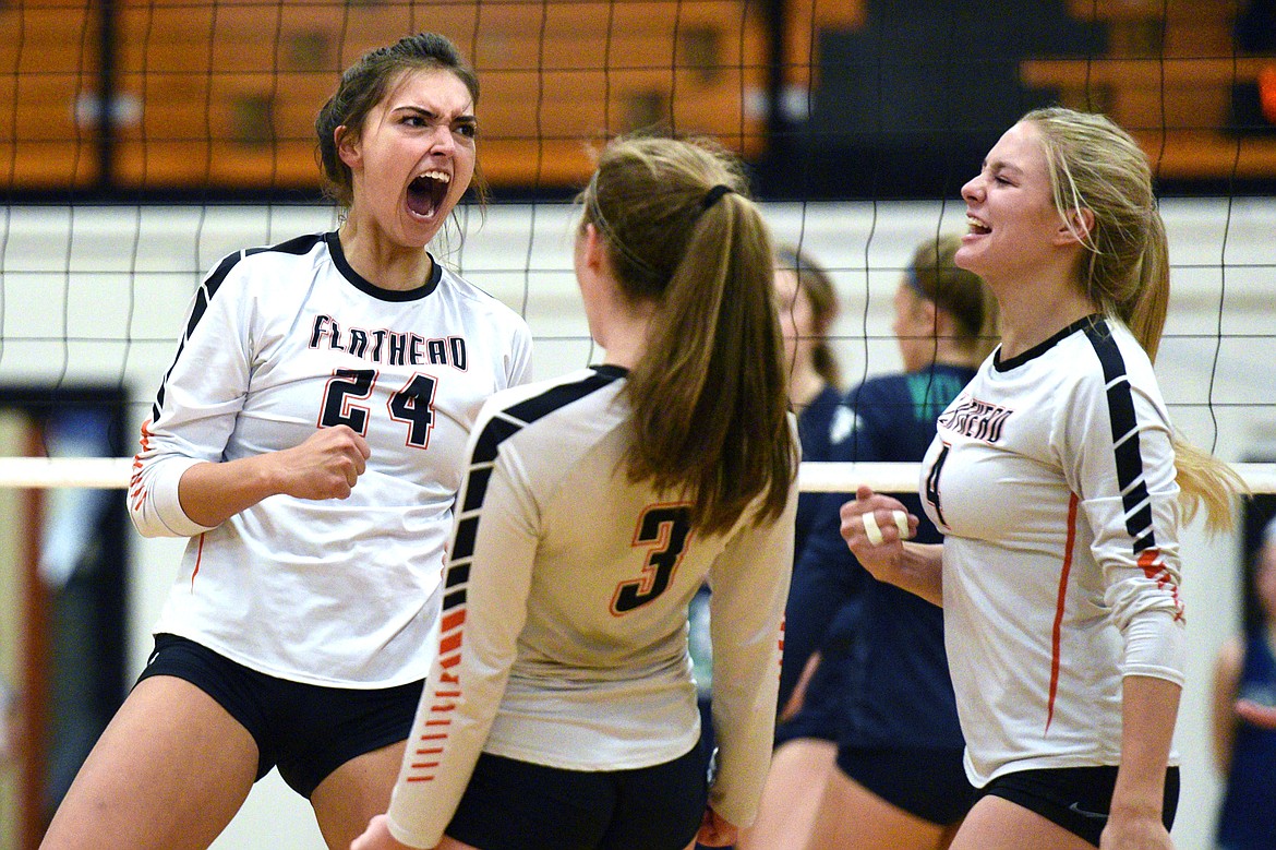 From left, Flathead's Taylor Henley (24), Sierra Wilhelm (3) and Jaylyn Fitch (4) celebrate after a point against Glacier during a Western AA playoff at Flathead High School on Thursday. (Casey Kreider/Daily Inter Lake)