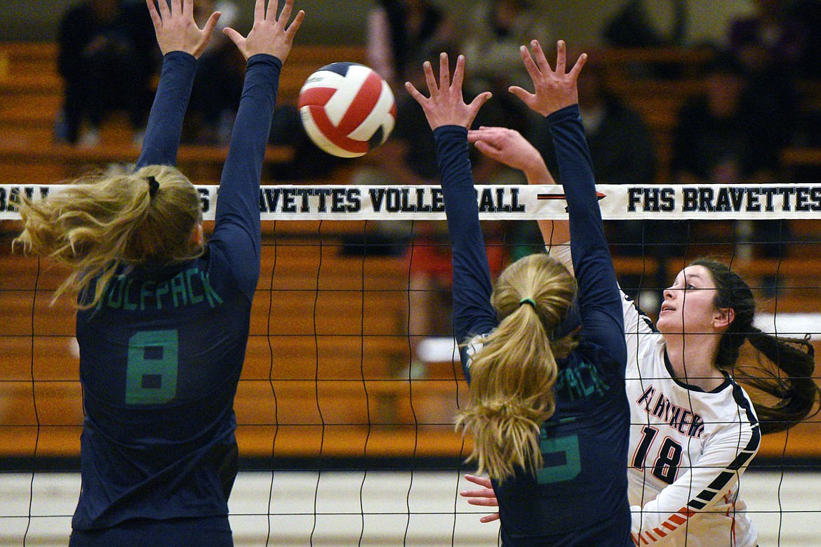 Flathead's Madde Boles (18) goes for a kill against Glacier's Aubrie Rademacher (8) and Kaylee Fritz (5) during a Western AA playoff at Flathead High School on Thursday. (Casey Kreider/Daily Inter Lake)