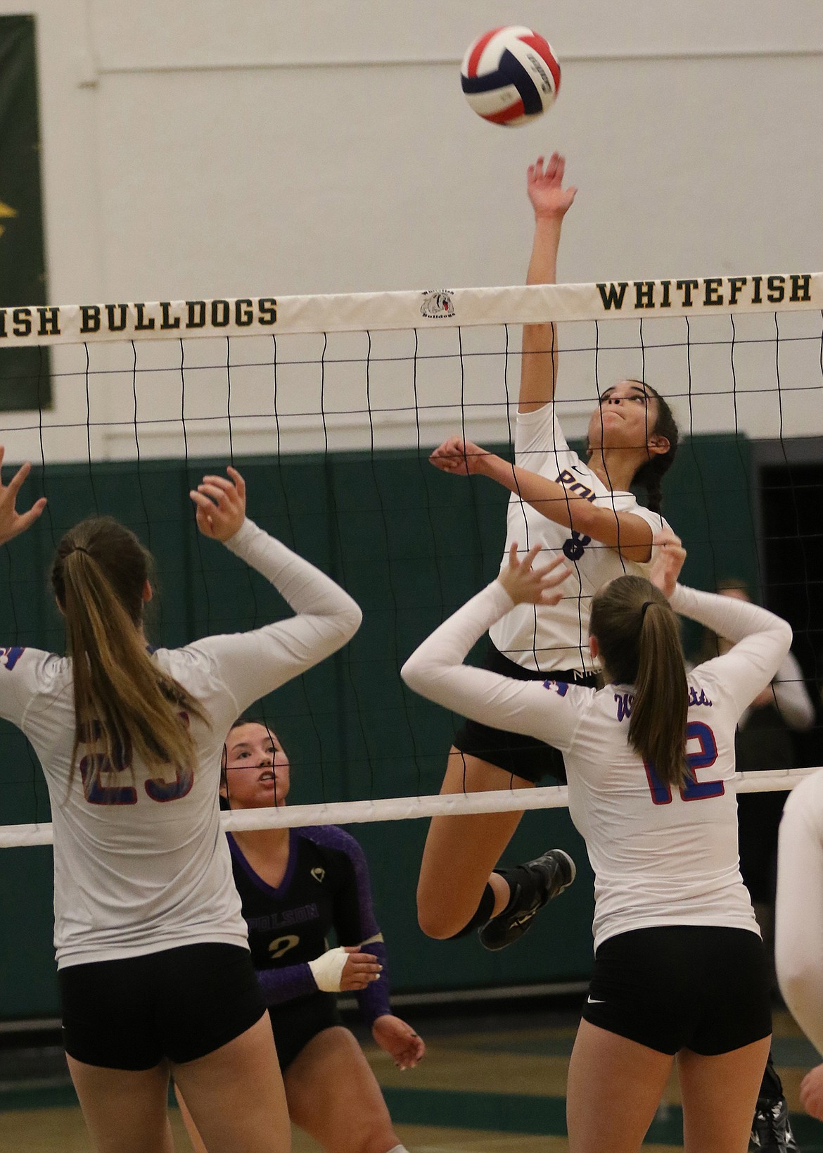 Lady Pirate Grace Quinones skies for a kill over two Columbia Falls blockers during a Western A Divisional Tournament last weekend in Whitefish. The Wildkats eliminated Polson in a 3-0 sweep. (Bob Gunderson/Lake County Leader)