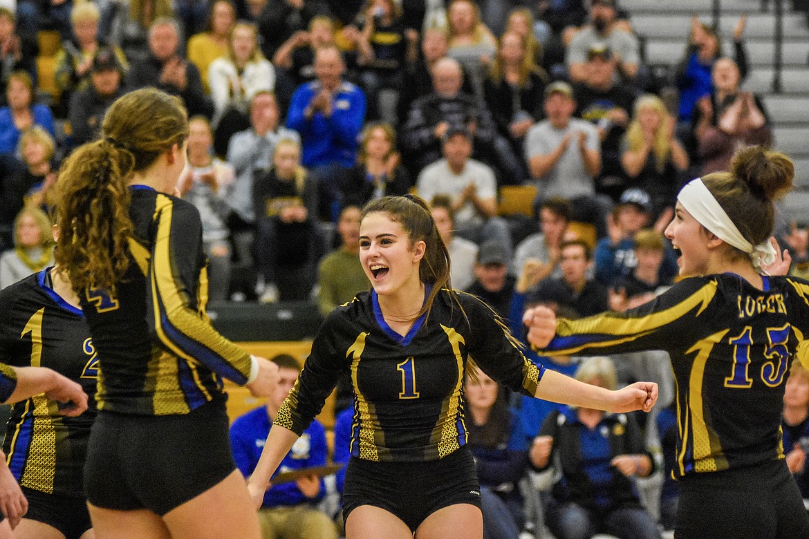 Libby seniors Jayden Winslow, Alli Collins and junior Ashlyn Monigold celebrate during a high point of their match against Corvallis Friday. (Daniel McKay/Whitefish Pilot)