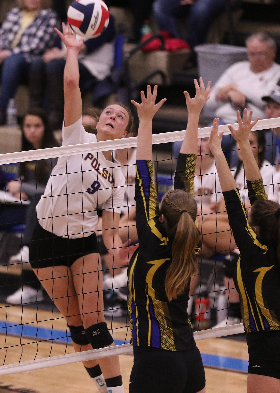 Maggie Todd (9) of Polson goes for a kill against two Libby blockers at the Northwest District volleyball tournament in Libby. The Lady Pirates fell to the No. 1-seeded Libby Loggers, 3-0.