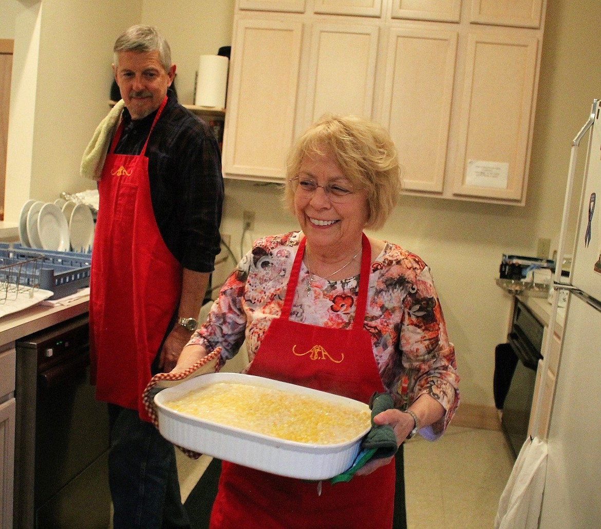 Church member Donna Haacke carries out a corn casserole at Stella&#146;s Annual Harvest Dinner. On the left is Dennis O&#146;Brien, who helped wash dishes at the event.