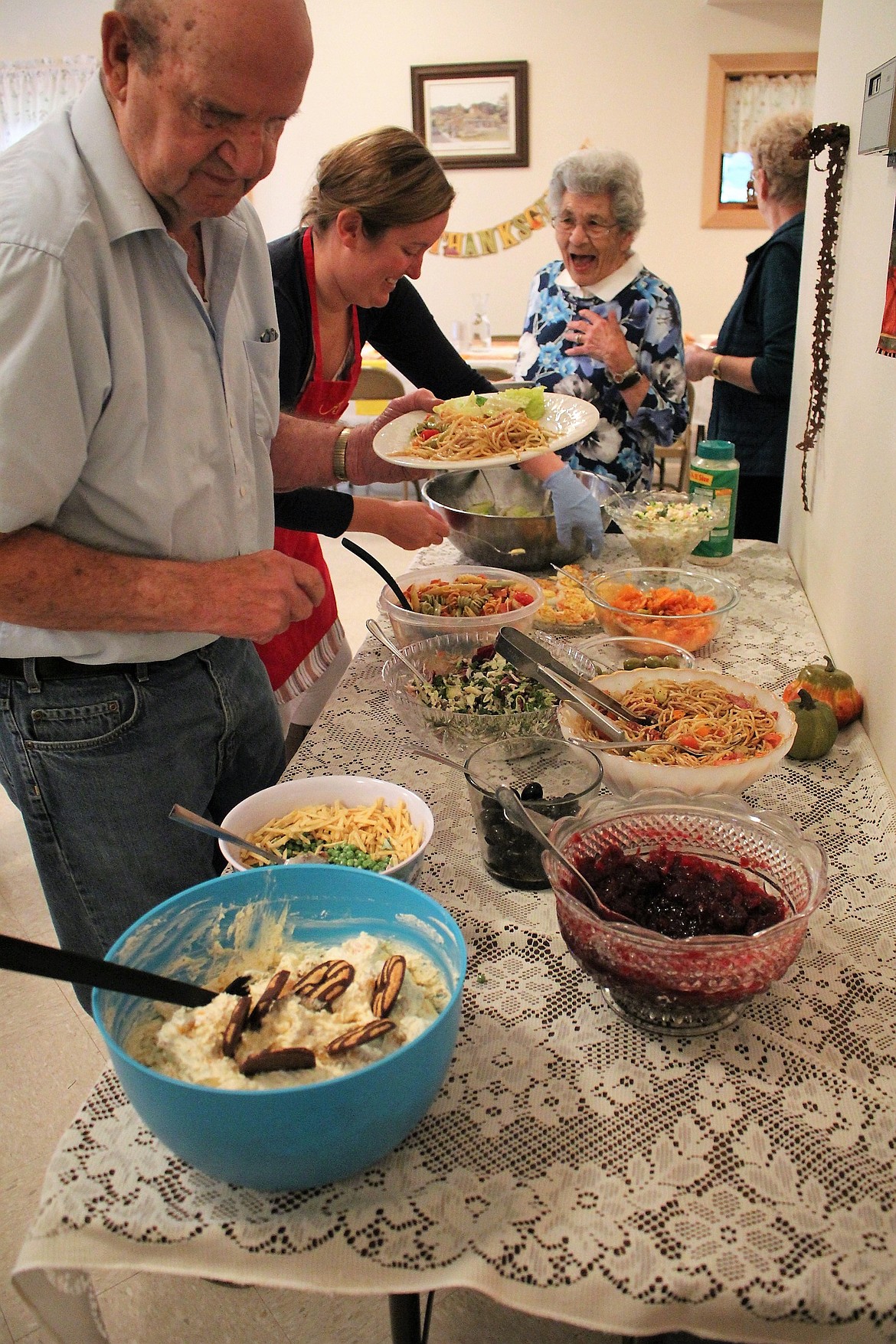 Long-time Alberton resident Joe Peterson fills his plate with salads at Stella&#146;s Harvest Dinner on Oct. 28. On the far right is Mickey Patch, who makes her Penny Carrot Salad, a dinner favorite.