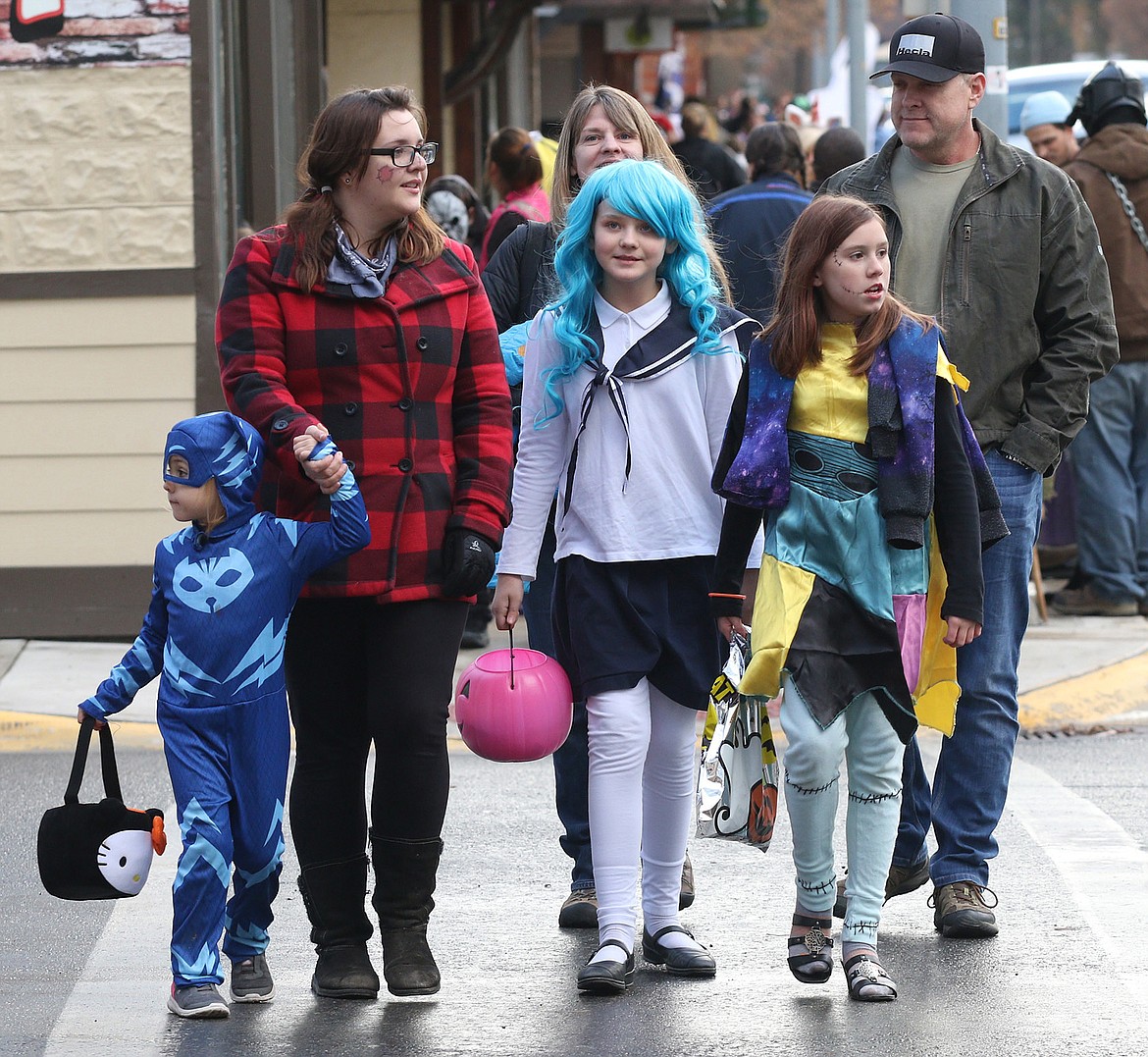 Trick-or-treaters &#151; from left in front, Elena Byers, her mother Alicia Rae Alkire, her friend Vivian Grosch and her sister Alexandria Byers, with Vivian&#146;s parents Amy and John following &#151; walk along Mineral Avenue in Libby Wednesday. (John Blodgett/The Western News)