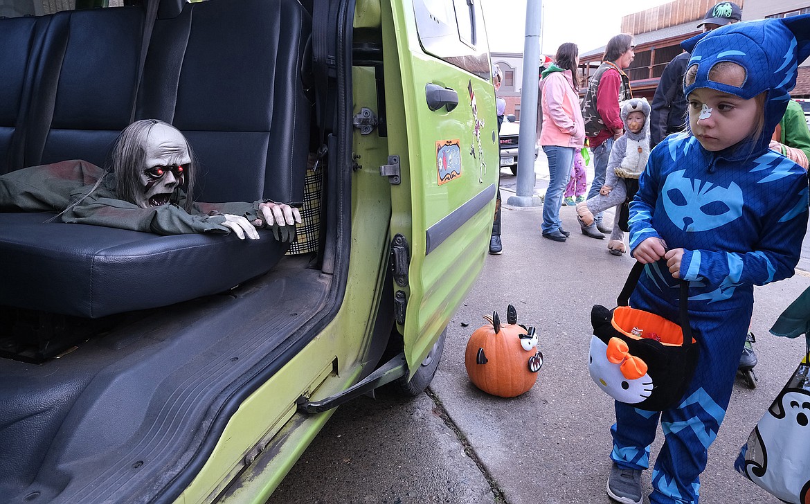 Elena Byers, 5, checks out a zombie in a Lincoln County Tranportation van while trick-or-treating with her family on Mineral Avenue in Libby Wednesday. (John Blodgett/The Western News)