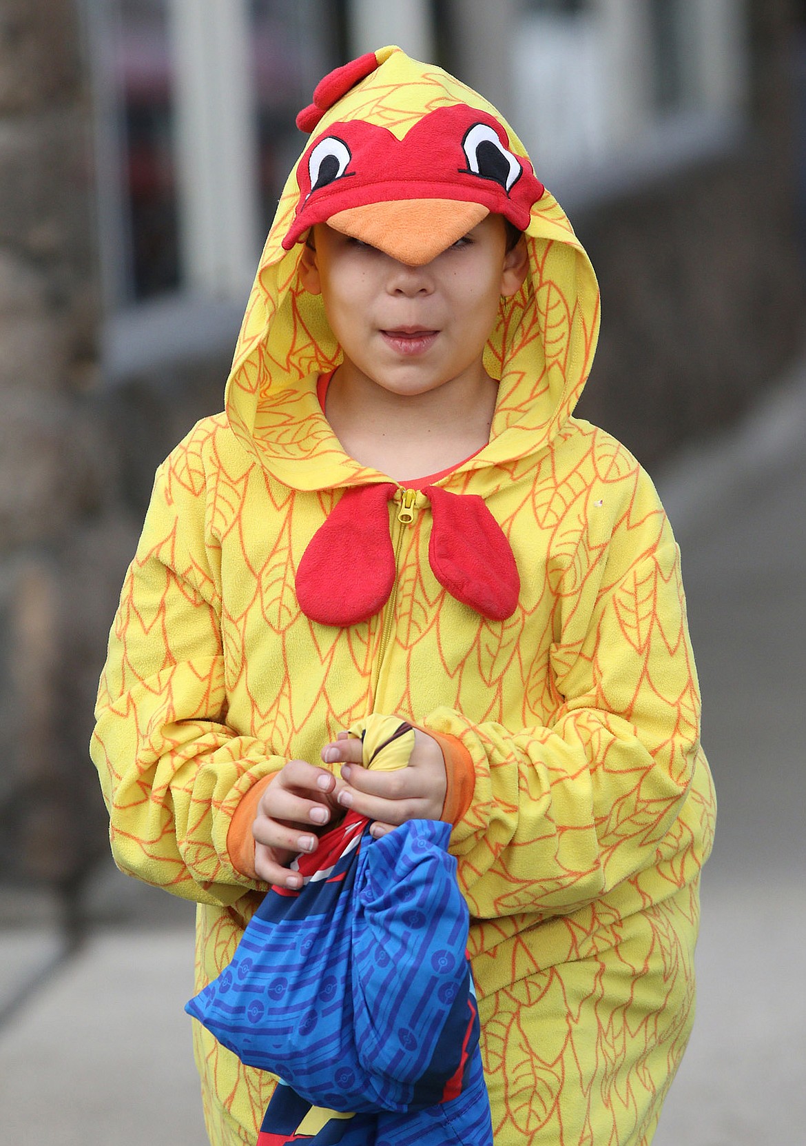 Dominic Condit, dressed as a chicken, crosses West 4th Street in Libby while trick-or-treating along Mineral Avenue Wednesday evening. (John Blodgett/The Western News)