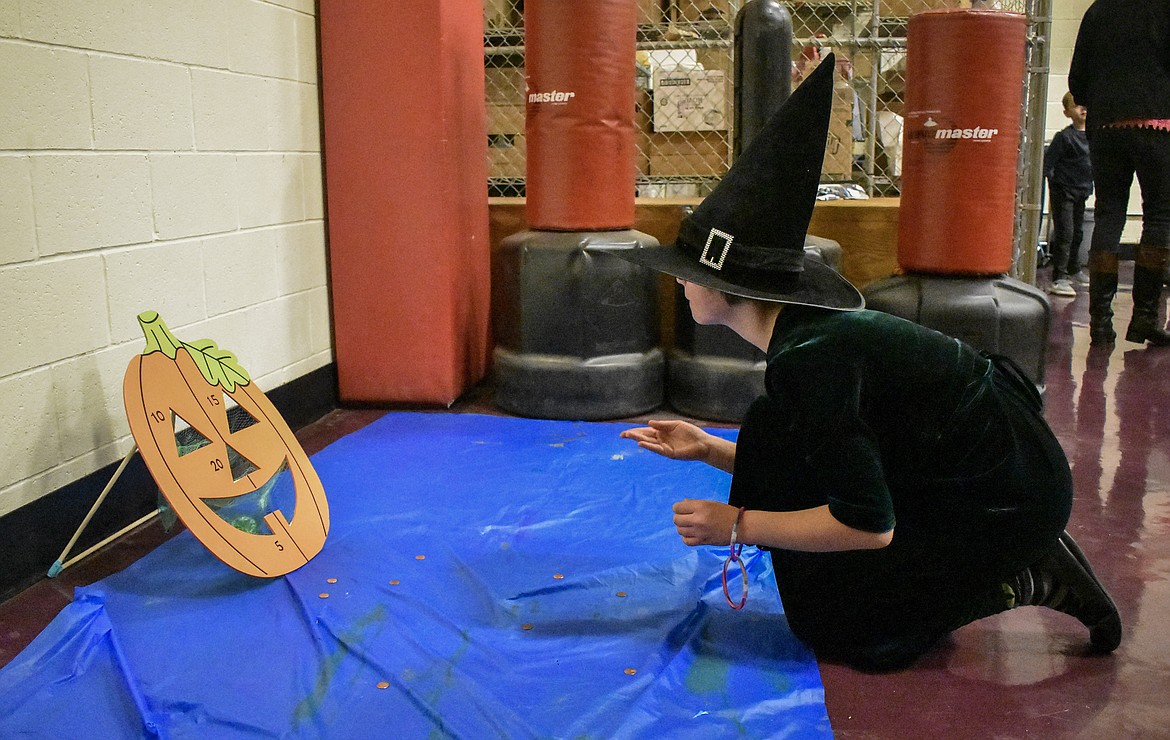 Casting pennies instead of spells, Shelby Cole plays the coin toss game at Troy&#146;s W.F. Morrison Elementary during the After School Program Halloween Carnival Wednesday, a part of the ASP&#146;s Lights On After School programs. (Ben Kibbey/The Western News)