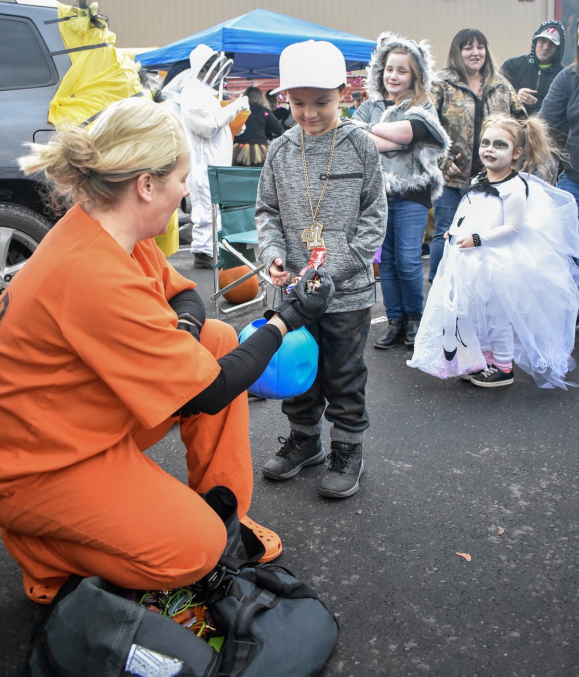 Troy Police Chief Katie Davis took on a persona on the other side of the law to hand out candy to Ben Powers and an eager line of trick-or-treaters at Trunk-or-Treat at the Troy Activity Center Wednesday. (Ben Kibbey/The Western News)