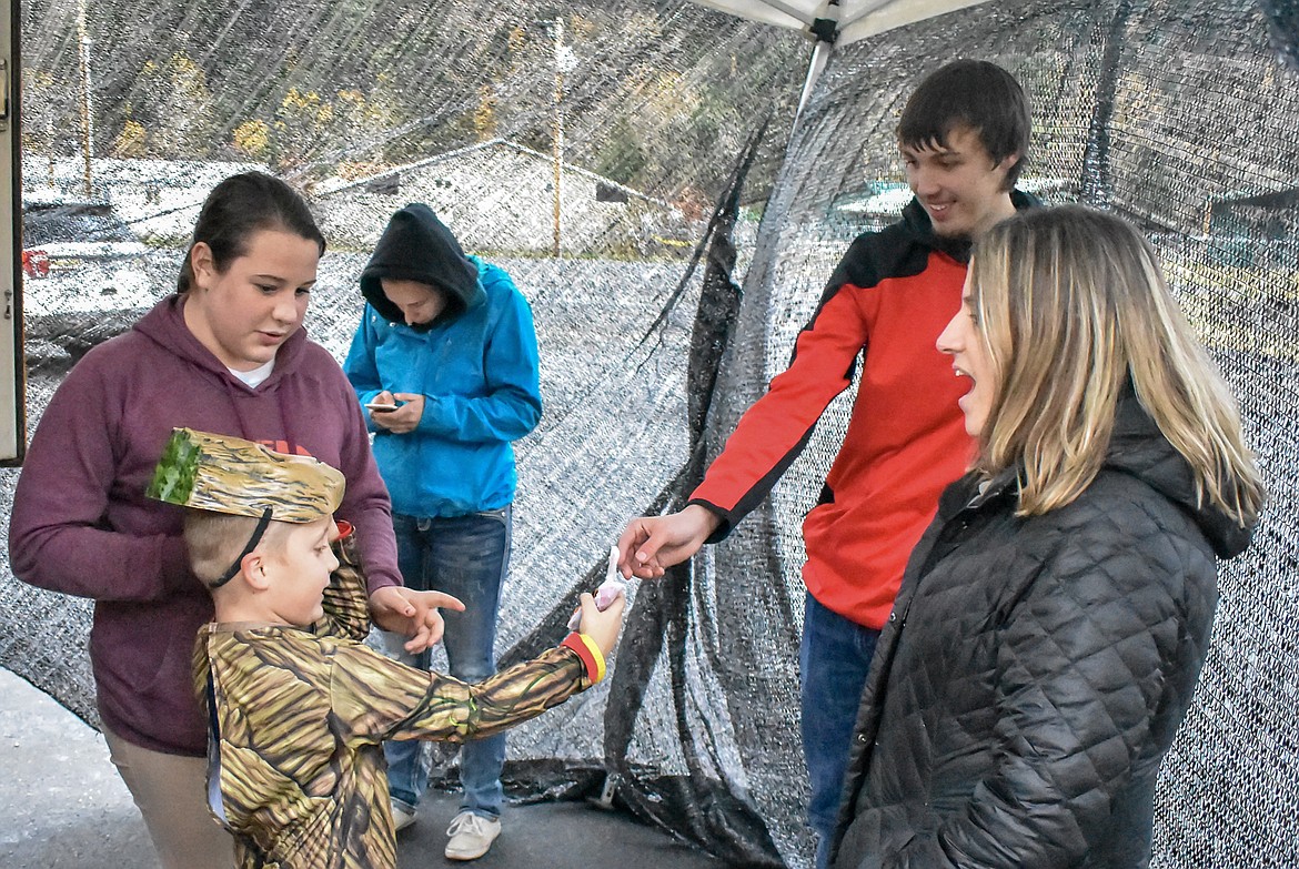 Zack McNeff as Groot of the Guardians of the Galaxy gets his candy from Dylan Cummings after making it through the haunted school bus at Trunk-or-Treat at the Troy Activity Center Wednesday. Also assisting with the haunted school bus were Tisee Lewis, Pam Tallmadge and (in back) Mackenzie Tallmadge. (Ben Kibbey/The Western News)