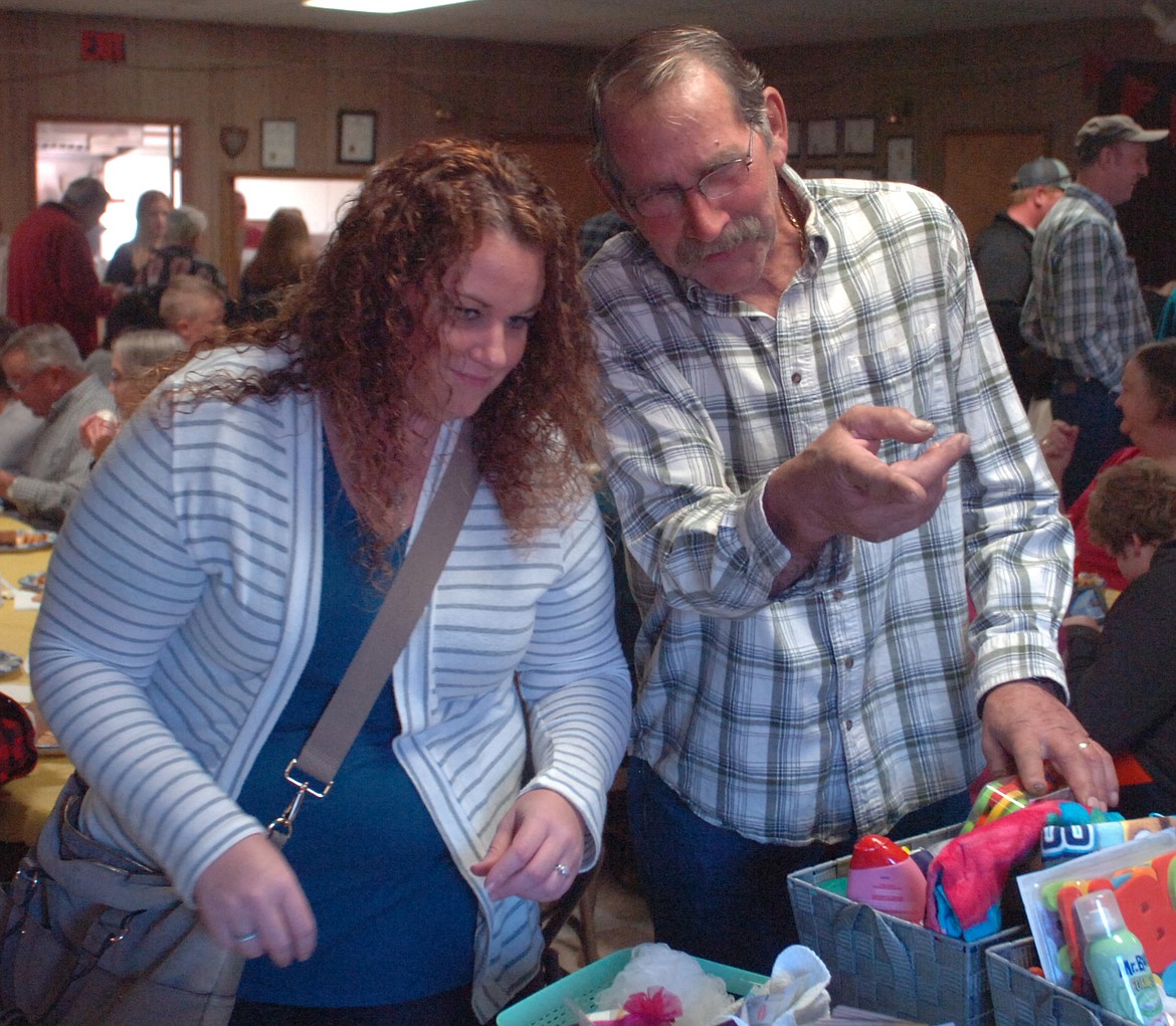 Melody Taylor and her father Don Stotz prepare to make a bid during the silent auction at the Cole Goodwin benefit Saturday evening at the Plains VFW.