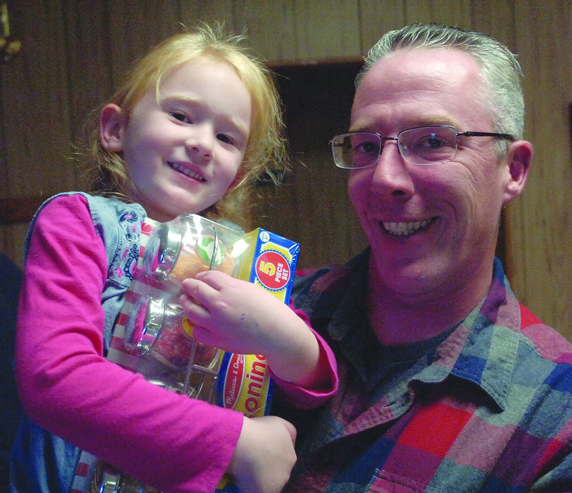 FOUR-YEAR-OLD Lily Taylor, in the arms of her dad Michael, holds a seasoning set that was part of a silent auction offering last Saturday during the Cole Goodwin benefit at the Plains VFW.