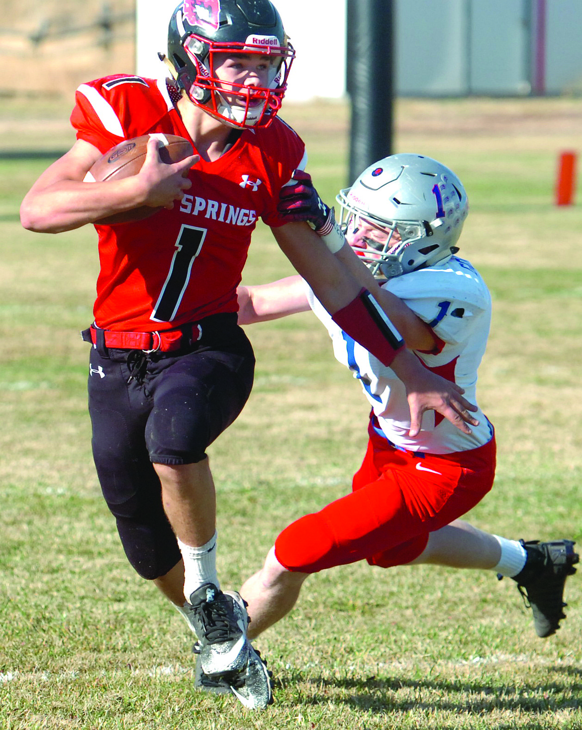 Hot SpringS junior quarterback Brandon Knudsen breaks an attempted tackle by Brodie Goodhart of Denton-Geyser-Stanford during last Saturday&#146;s 49-24 Savage Heat win in the first round of the state playoffs. (Joe Sova photos/Clark Fork Valley Press)