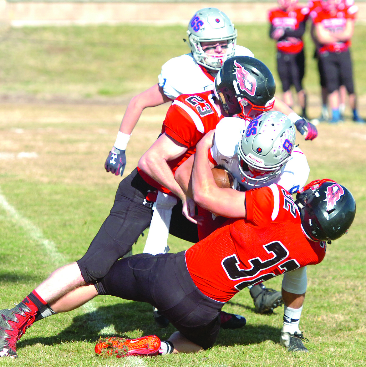 Hot Springs defenders Tyler Knudsen (32) and Luke Waterbury (23) wrap up DGS quarterback Dylan Taylor during last Saturday's Savage Heat playoff victory.