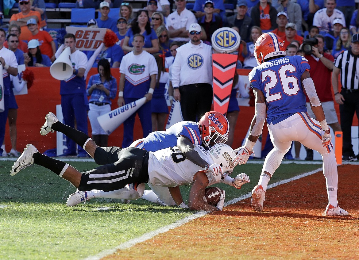 JOHN RAOUX/Associated Press
Idaho wide receiver Jeff Cotton catches a 12-yard pass for a touchdown against Florida defensive back Brian Edwards, left, and defensive back John Huggins (26) during the second half Saturday in Gainesville, Fla.