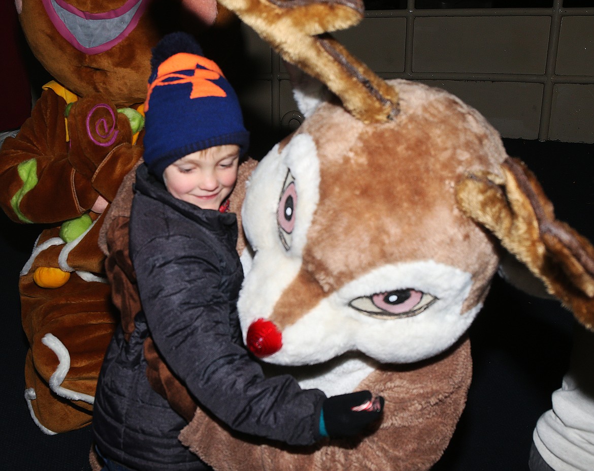 Hunter Green, 5, gives Rudolph a big hug during a Journey to the North Pole cruise Thursday night.