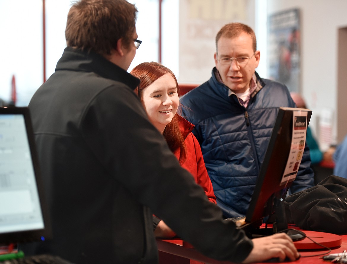 Amy Knapton of Kalispell smiles as she and Assistant Manager Michael Stevens pick out her new set of tires for winter on Wednesday, November 14, at Discount Tire. In the background is David Boye of Black Daimond Mortgage in Whitefish, the creator of the Tires for a Change program.(Brenda Ahearn/Daily Inter Lake)