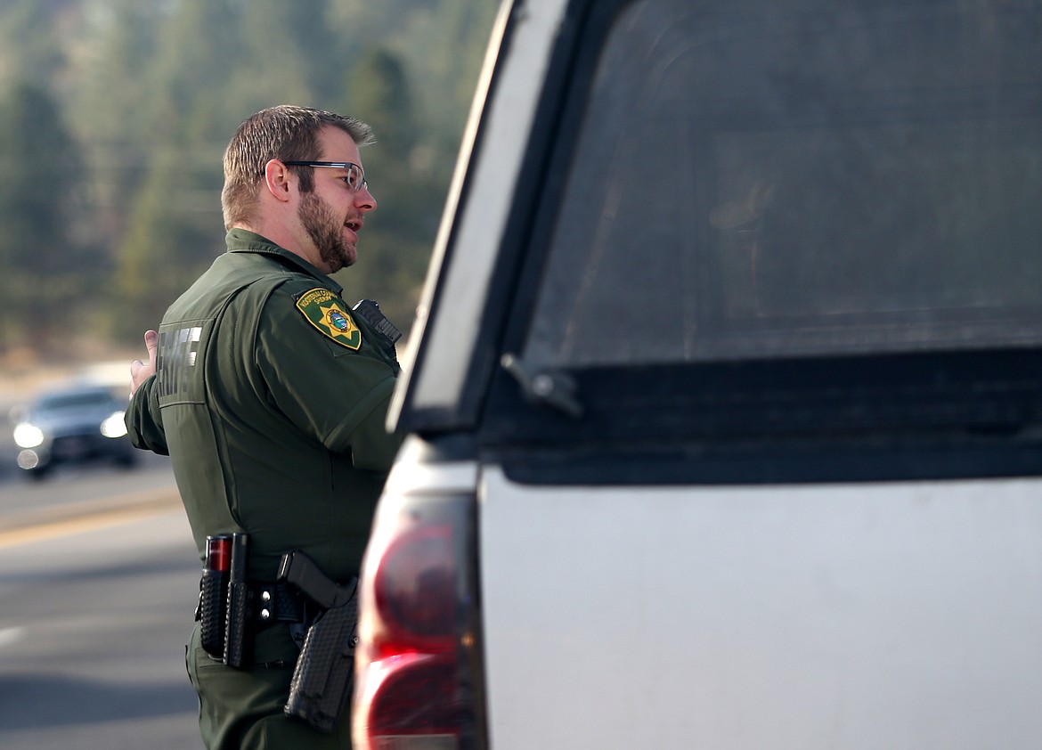 Kootenai County Sheriff deputy Jeremy Prosch speaks with a motorist about the need to change lanes while there is an emergency vehicle on the side of the road.