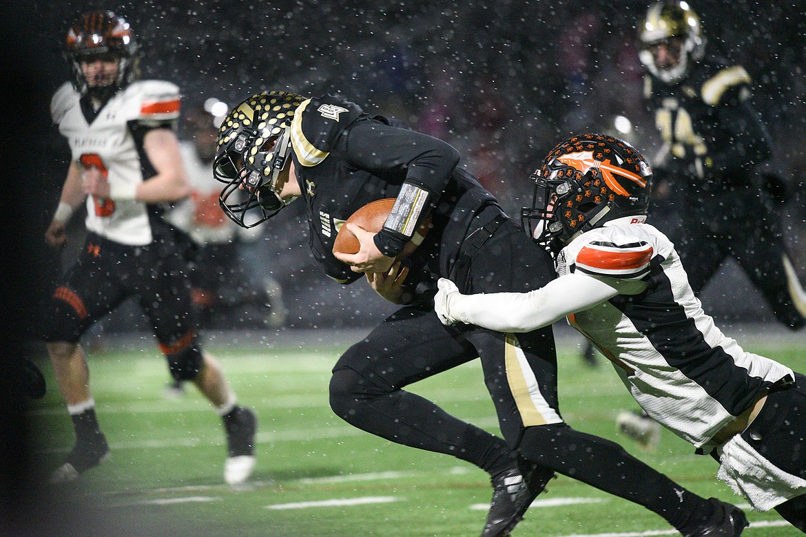 Billings West quarterback Josh Erbacher (1) is pulled down by Flathead defender Logan Siblerud (1) in the Class AA state championship at Wendy&#146;s Field at Daylis Stadium in Billings on Friday. (Casey Kreider/Daily Inter Lake)