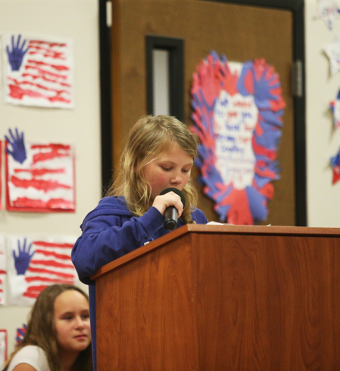 Sixth-grader Aubrey Jenson reads an essay during Spirit Lake Elementary School's Veterans Day assembly on Monday.  (LOREN BENOIT/Press)