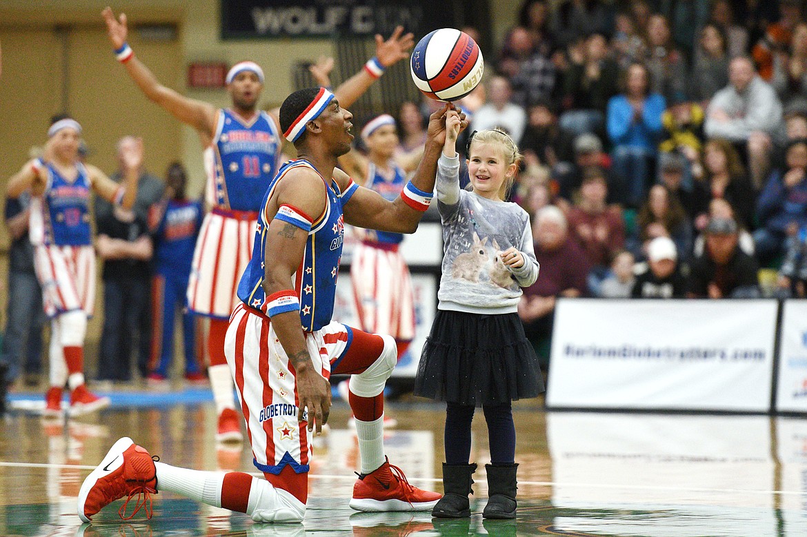 Harlem Globetrotter &quot;Hi-Lite&quot; spins the basketball on a young fan's finger during an intermission in a game against the Washington Generals at Glacier High School on Tuesday, Nov. 13. (Casey Kreider/Daily Inter Lake)