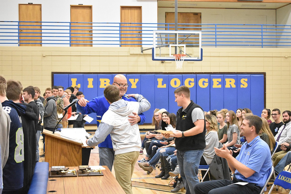 Libby High School football team Head Coach Neil Fuller congratulates senior JJ Davis during the Fall Awards Assembly Thursday. Davis made All State and First Team All Conference. He was also voted “Most Inspirational” and received the Coach’s Award. (Ben Kibbey/The Western News)