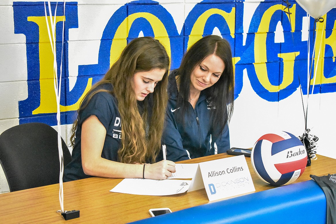 Libby senior Alli Collins signs to play volleyball at Dickinson State University in Dickinson, North Dakota, during a short ceremony Wednesday. Pictured are Collins and Dickinson Head Coach Jennifer Hartman.