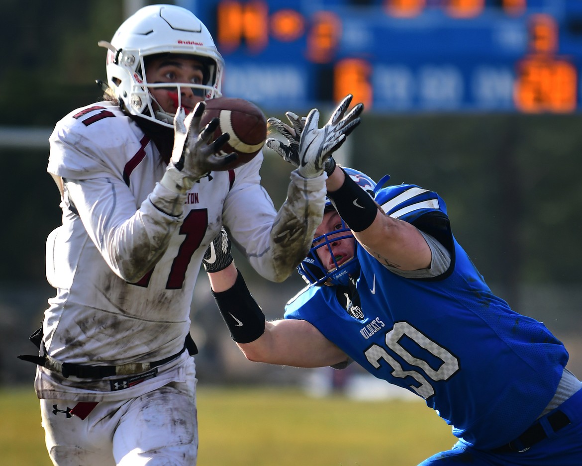 Wildcat Joe Clewien tries to knock the ball away from Hamilton defender Tyler Barnes as he intercepts a Columbia Falls pass in the third quarter Saturday. (Jeremy Weber photo)