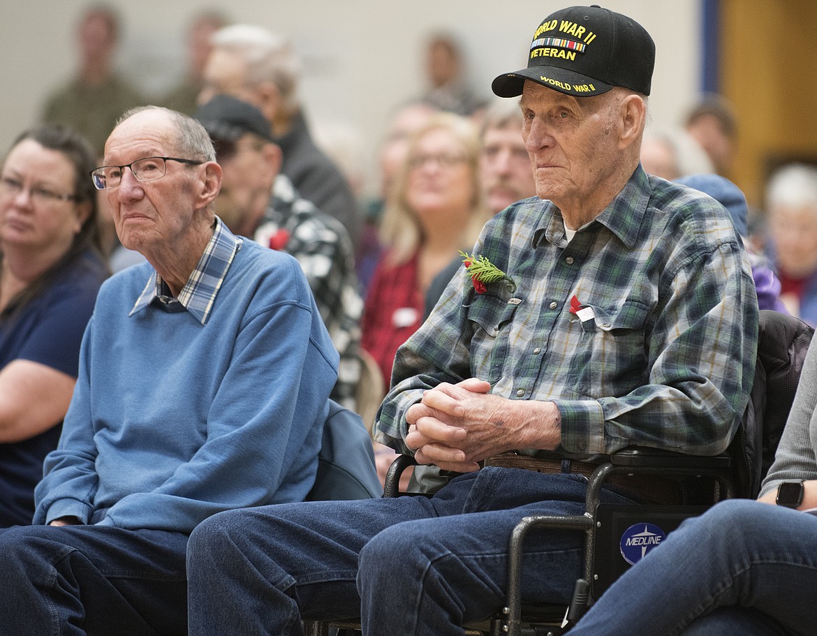 Special Guest Veterans Jack Dunne (left) and Jim Crow take in the ceremony at Columbia Falls High School Friday. Both served in World War II, Dunne in the Army Air Corps in the Pacific and Crow in the Army in Europe. (Jeremy Weber photo)