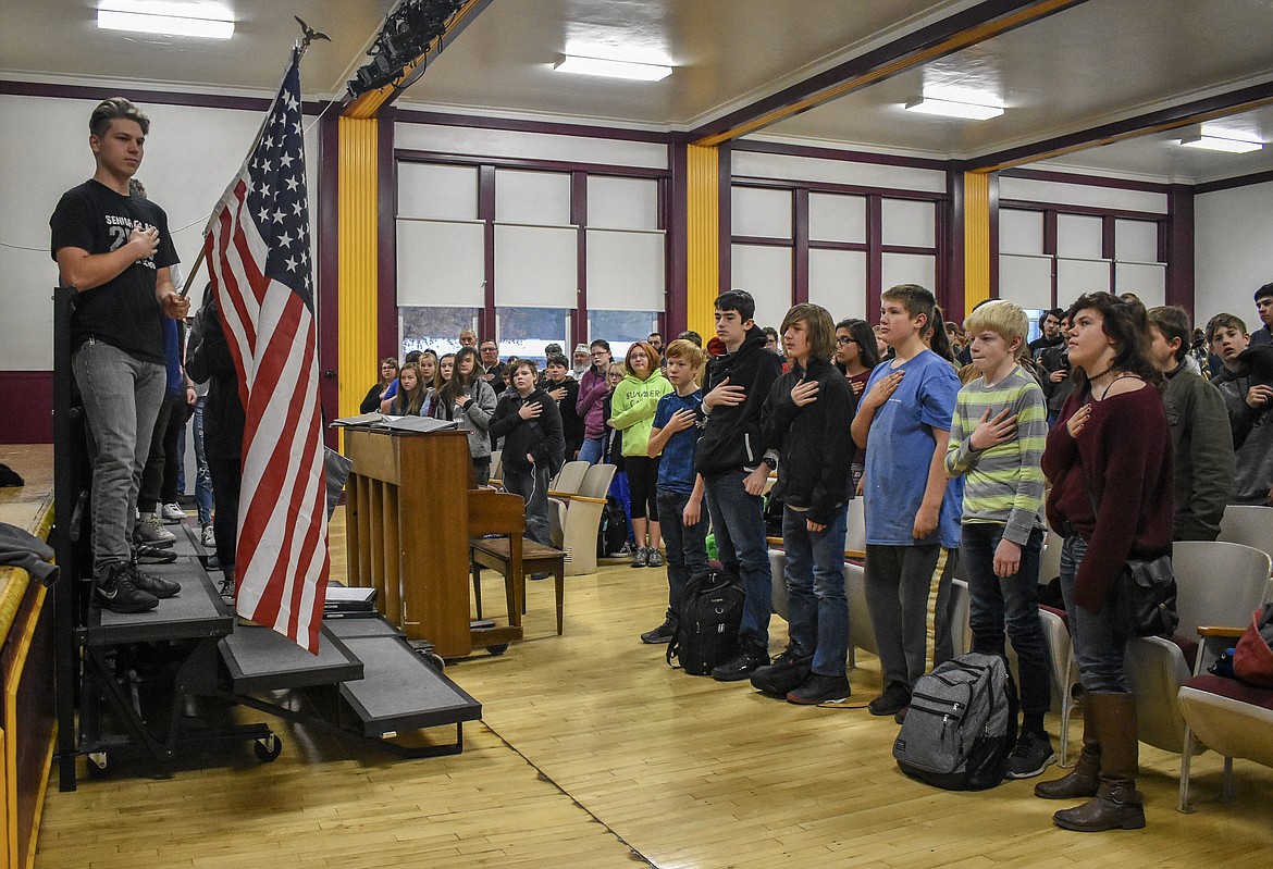 Students at Troy Middle-High School and U.S. military veterans join in saluting the flag during the National Anthem at a Veteran&#146;s Day ceremony in the school&#146;s auditorium Monday. (Ben Kibbey/The Western News)