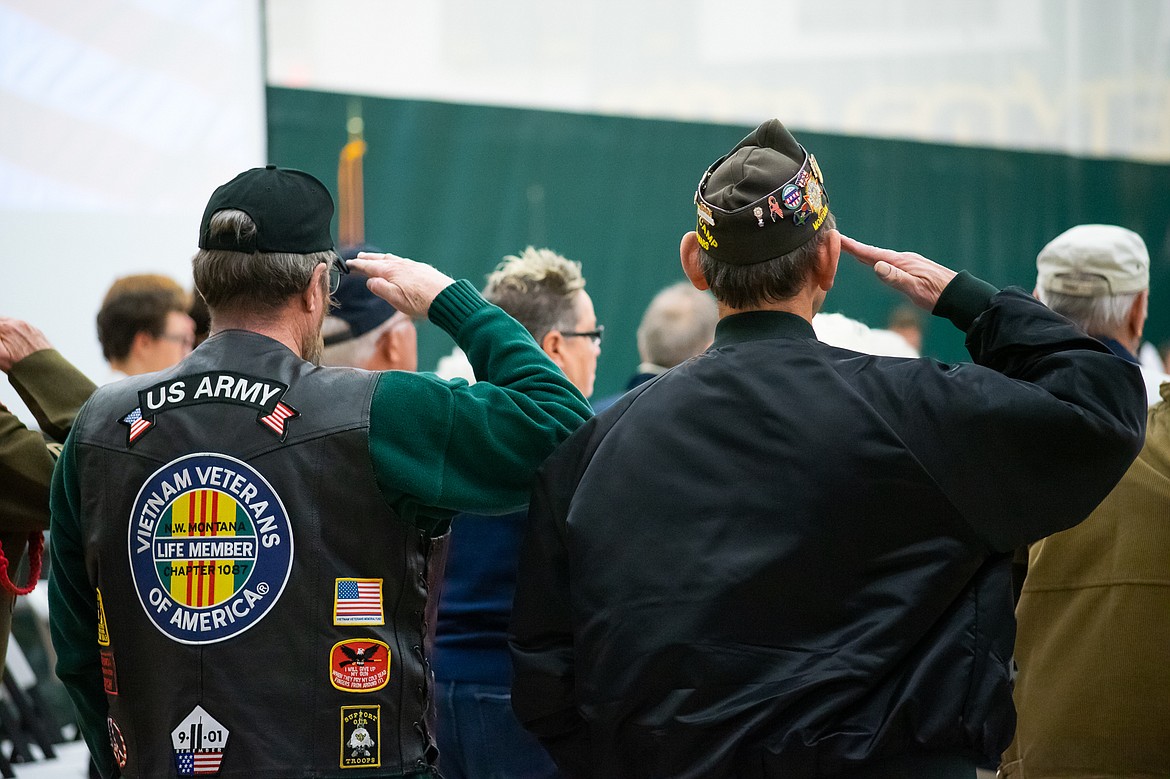 Two veterans salute the flag during a Veterans Day assembly last Friday.