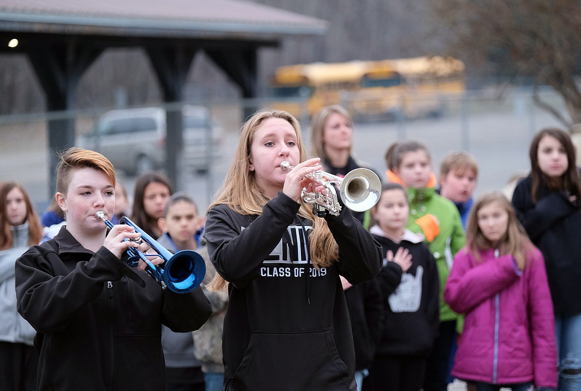 Jacqueline Wisdom, lfet, and Cierra Swagger play taps during a Monday morning flag raising ceremony at Libby Elementary School. (John Blodgett/The Western News)