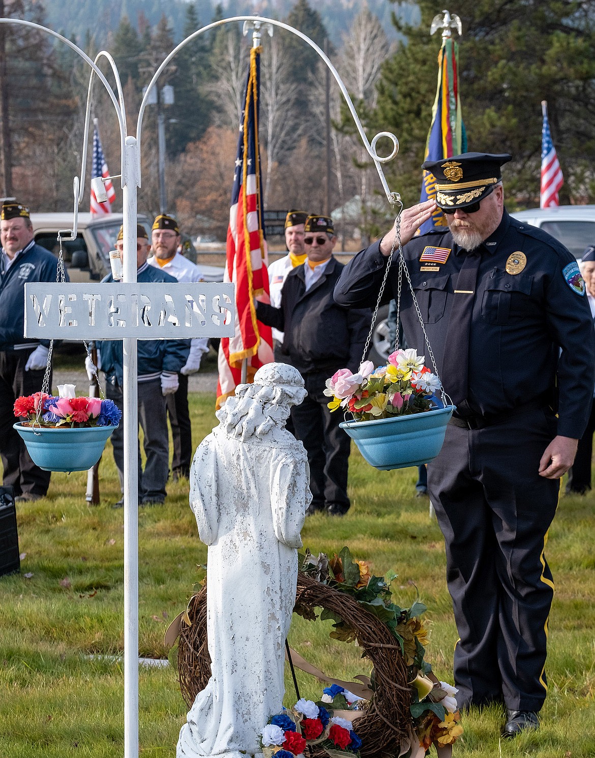 Libby Police Chief Scott Kessel salutes after placing a wreath at the Libby Cemetery Veterans Memorial on Sunday, Nov. 11, 2018. (John Blodgett/The Western News)