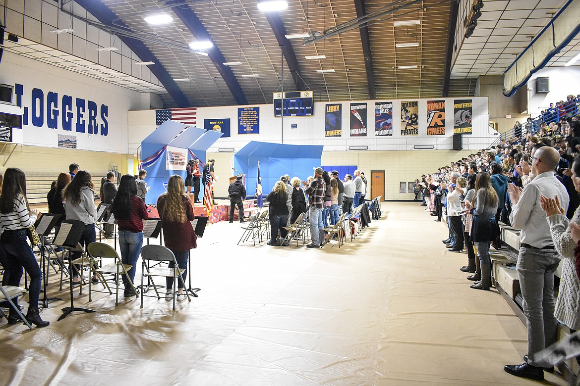 Community members, students and fellow veterans give a standing ovation to U.S. Marine Corps veteran Ramsey Smith after his talk during the Veterans Day observance in the Ralph Tate Memorial Gymnasium at Libby High School Monday. Smith gave a frank recollection of growing up with his brother, Raleigh, in Troy, of their enlistment in the Marines around the same time, and the mental and emotional scars he carries from his own service and from the death of his brother in Fallujah, Iraq. He told the audience that being asked if he ever killed someone or to tell stories of his time overseas is painful, but that the gratitude shown when people thank service members for their service makes it worth the sacrifices made. (Ben Kibbey/The Western News)