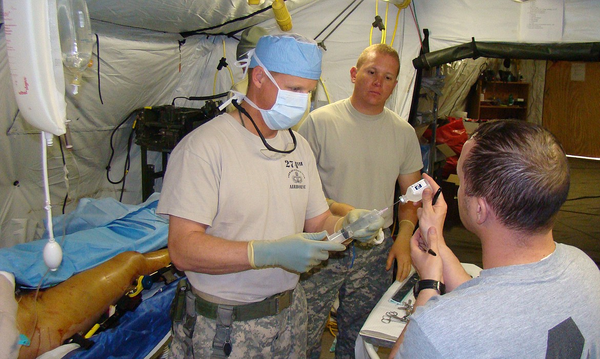 Dr. Robert E. Blease, M.D., wearing a scrubs cap, is pictured during his time in the U.S. Army when his Forward Surgical Team&#146;s deployment to Afghanistan. (Photos courtesy of Dr. Robert Blease and Clark Fork Valley Hospital)