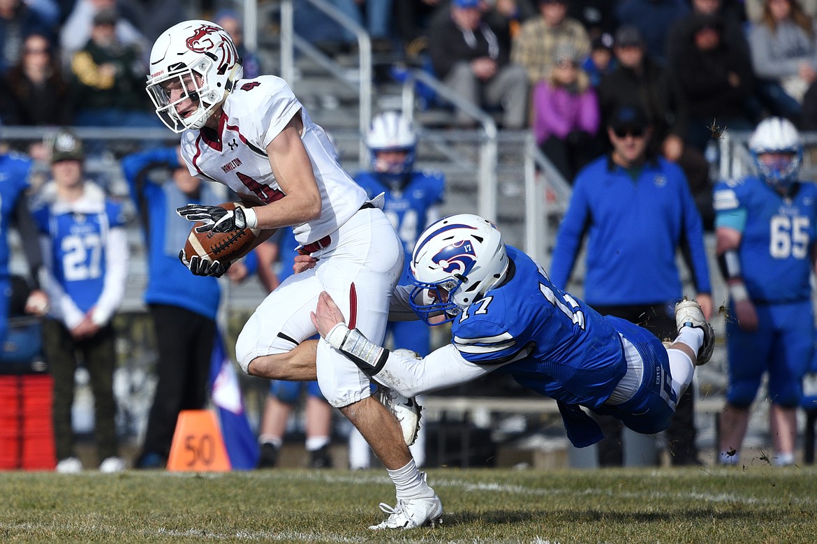 Hamilton wide receiver Caden Brown (4) is tackled by Columbia Falls defensive back Drew Morgan (17) on a first-quarter reception in a Class A semifinal playoff game at Columbia Falls High School on Saturday. (Casey Kreider/Daily Inter Lake)