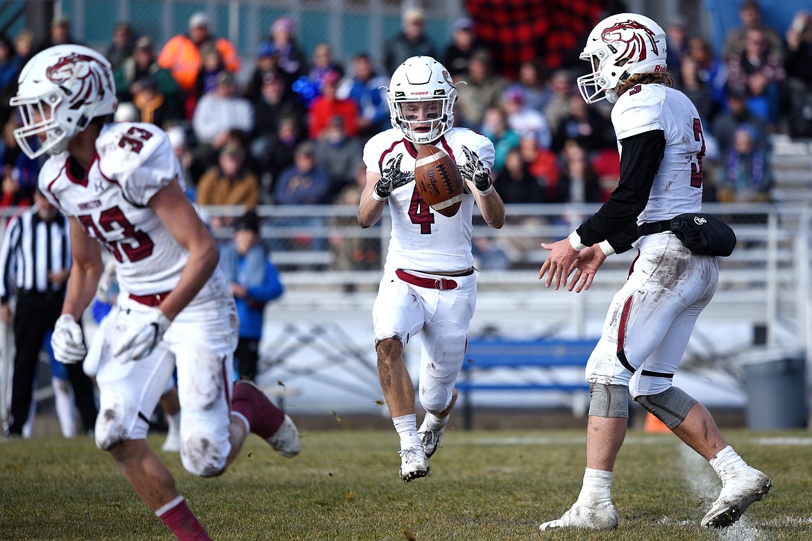 Hamilton wide receiver Caden Brown (4) takes a handoff from quarterback Carson Rostad (3) in the first half against Columbia Falls in a Class A semifinal playoff game at Columbia Falls High School on Saturday. (Casey Kreider/Daily Inter Lake)