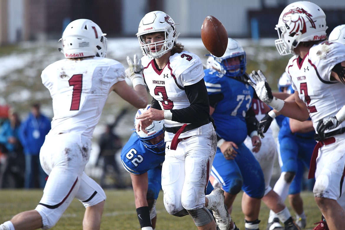 Hamilton quarterback Carson Rostad (3) pitches to wide receiver Camron Rothie (1) on a reverse in the first half against Columbia Falls in a Class A semifinal playoff game at Columbia Falls High School on Saturday. (Casey Kreider/Daily Inter Lake)