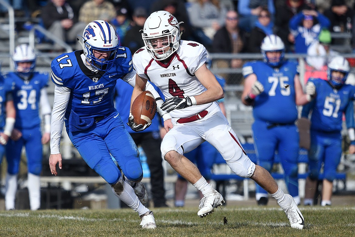 Hamilton wide receiver Caden Brown (4) looks upfield after a first-quarter reception with Columbia Falls defensive back Drew Morgan (17) in pursuit in a Class A semifinal playoff game at Columbia Falls High School on Saturday. (Casey Kreider/Daily Inter Lake)