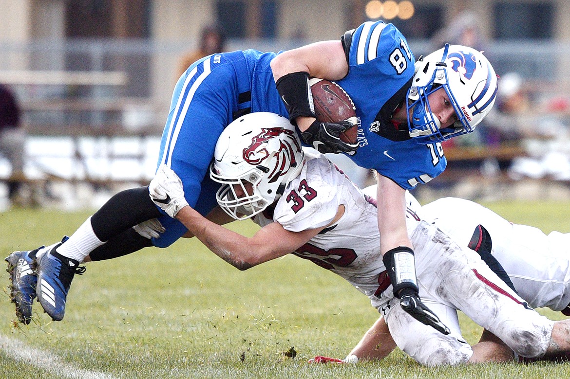 Columbia Falls wide receiver Logan Bechtel (18) is tackled by Hamilton defender Michael Golden (33) in the fourth quarter in a Class A semifinal playoff game at Columbia Falls High School on Saturday. (Casey Kreider/Daily Inter Lake)