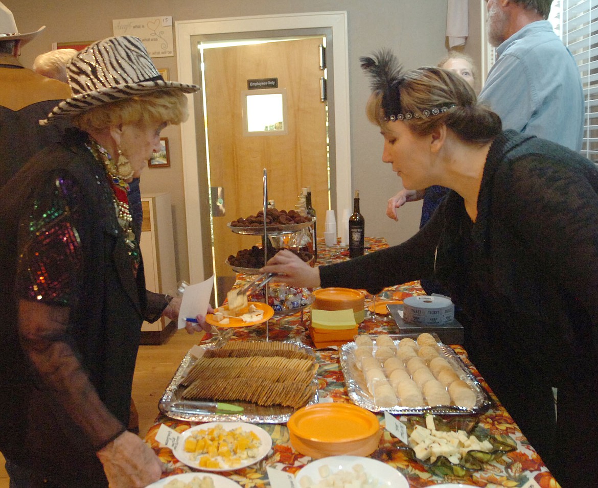 Charlie Scott serves a variety of cheeses to Martha &#147;The Great&#148; Snyder during the Hot Springs Artists Society fundrasier last Saturday night at Symes Hot Springs. (Joe Sova photos/Clark Fork Valley Press)