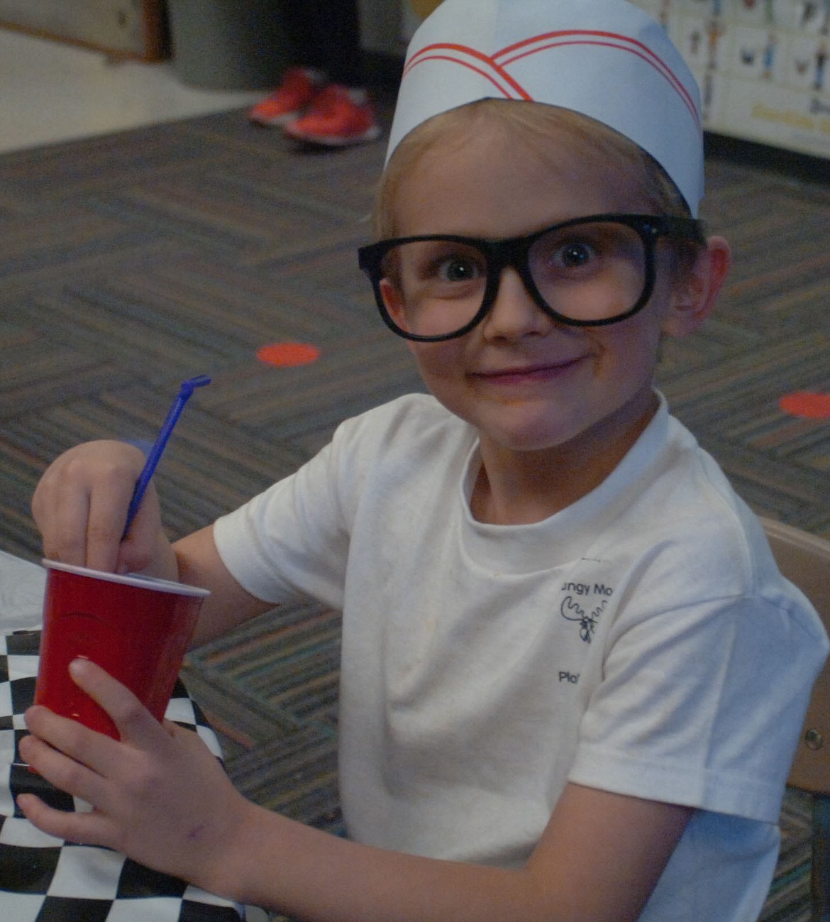 Kindergartner Brenden Allen gets the most out of his root beer float at Mrs. Hillerman&#146;s Kinder Cafe last Friday. How about that soda fountain hat and those cool glasses! See more photos from the cafe online at www.vp-mi.com.