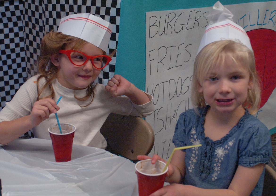 Plains kindergartners Jenalee VonHeeder and Mady Marjerrison chat while enjoying a root beer float during &#146;50s diner day at Mrs. Hillerman&#146;s Kinder Cafe last Friday afternoon. (Photos by Joe Sova/Clark Fork Valley Press)