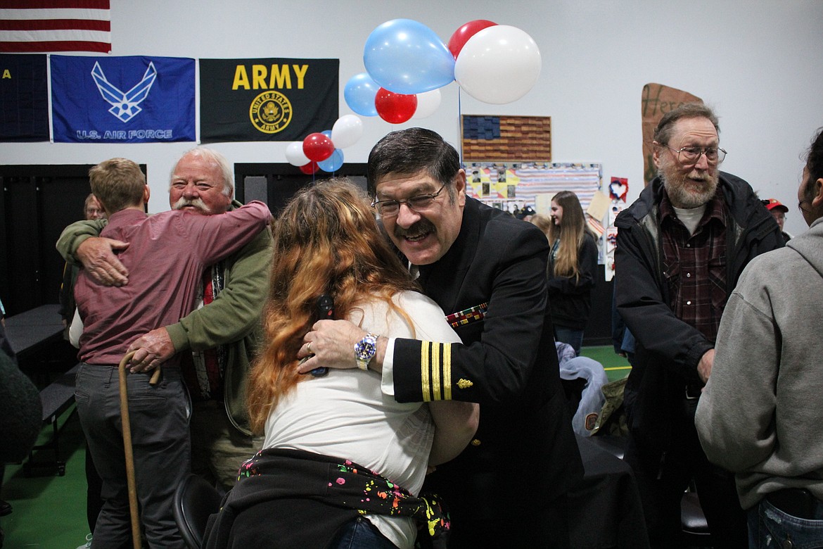 Ernie Ornelas, former Mineral County sheriff and Navy veteran (middle), receives a hug during a breakfast held at St. Regis School on Nov. 8 honoring men and women who have served in the military. To the left is John Cheesman, who served in the Army, and Scott Burrows (right), who served in the Navy.